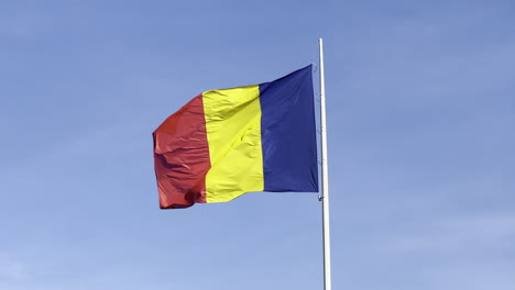 romanian national flag on a windy day against a blue sky
