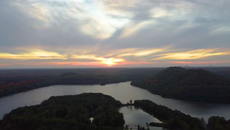 overgrown landscape and majestic lake during golden sunset, aerial view