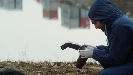 forensic investigator taking photos of dead person, crime scene in harbor