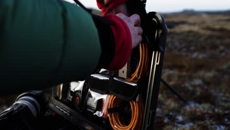 fotógrafo pasando por un estuche de vuelo organizado con bolsillos para cables, manos cerradas