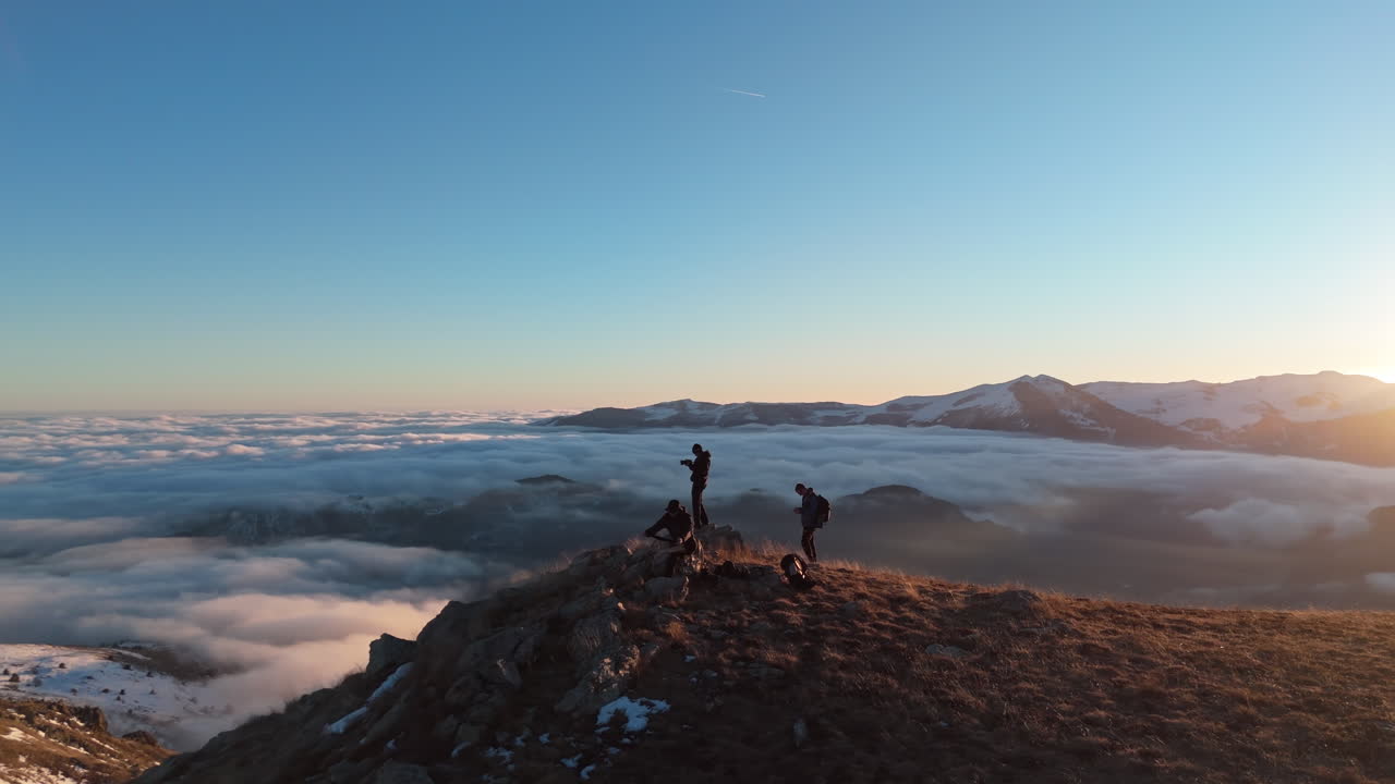 People on mountain top at sunrise, enjoying stunning views, feeling free