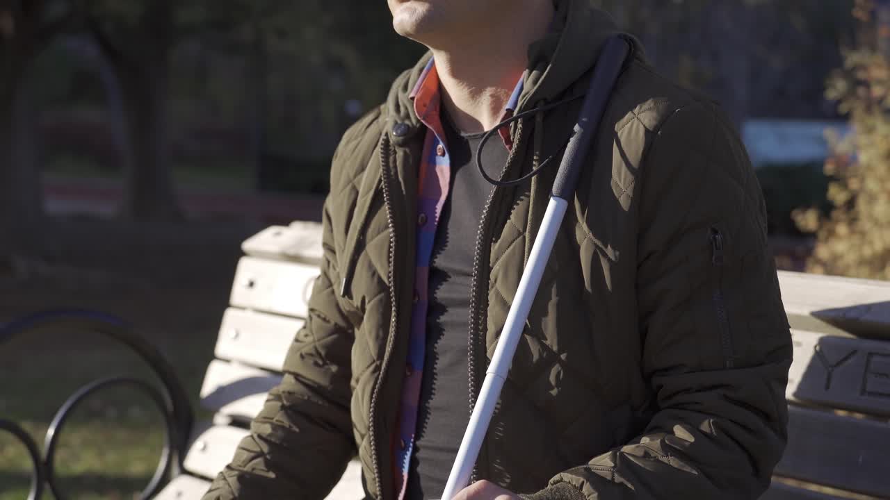 el estado pensativo del ciego sosteniendo un bastón en el parque.
