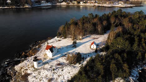 Luftumlaufbahn-über-Einem-Schneebedeckten-Leuchtturm-Der-Insel-Curtis-Bei-Sonnenaufgang-Mit-Langen-Schatten-Im-Schnee