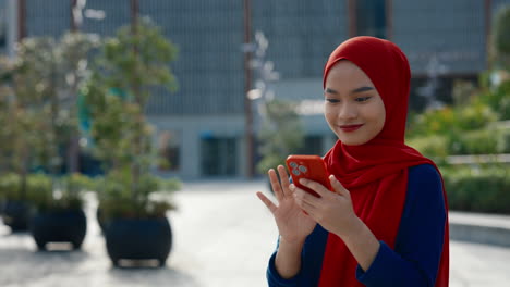 Happy Muslim Woman Using Smartphone in an Urban Setting