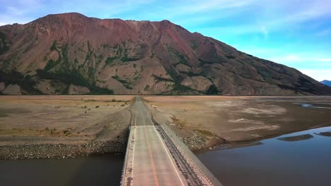 spectacular backward flight above empty, desolate, remote and rural yukon wilderness alaska highway by majestic, colorful, imposing and impressive sheep mountain range by kluane lake, aerial pull back