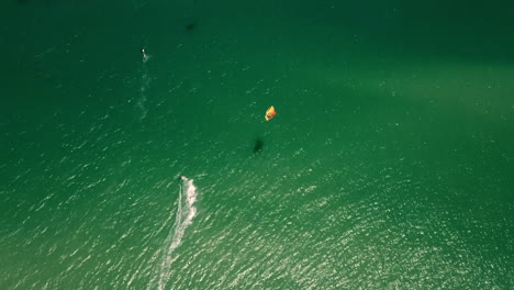 Drohnenaufnahme-Von-Oben-Nach-Unten-In-Großer-Höhe-Von-Kitesurfern-Im-Türkisfarbenen-Atlantik