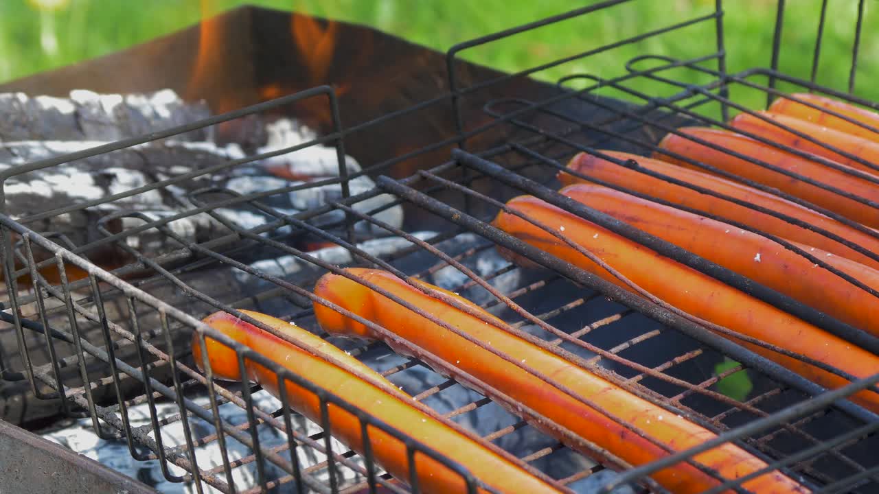 cocinar salchichas de carne en una vieja parrilla de barbacoa al aire libre oxidada, primer plano