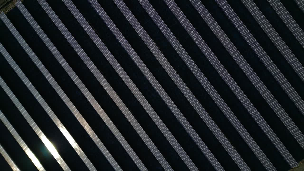 Large grid of photovoltaic solar panels, producing green electricity for sustainability and eco friendly power. vertical bird's eye view drone Unbelievable aerial view ascending raise up drone