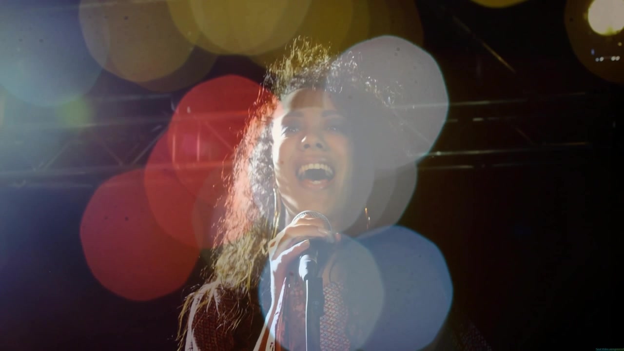 Starting with first note, female singer performing music, leaning back, lens flares obscuring face
