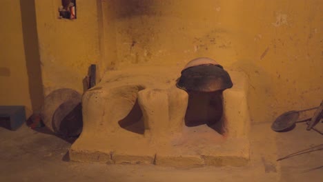 an old mud cooking stove or chulha in a village kitchen in rural india