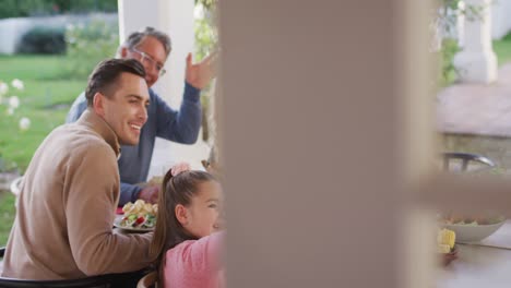 Video-of-happy-caucasian-parents,-daughter-and-grandparents-taking-selfie-at-outdoor-dinner-table