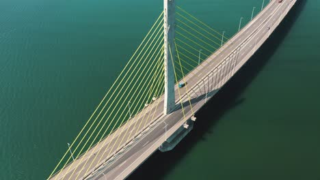 Bridge-traffic-above-turquoise-color-ocean-orbital-aerial-view