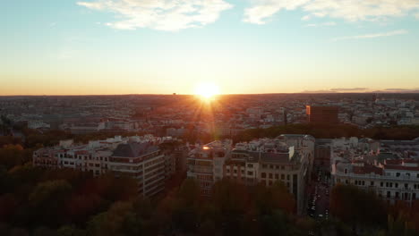 Pull-ball-footage-of-large-multistorey-apartment-buildings-at-city-park.-Revealing-cityscape-against-setting-sun.