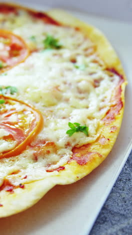 pizza al horno con aderezos de tomate cereza en la caja de entrega