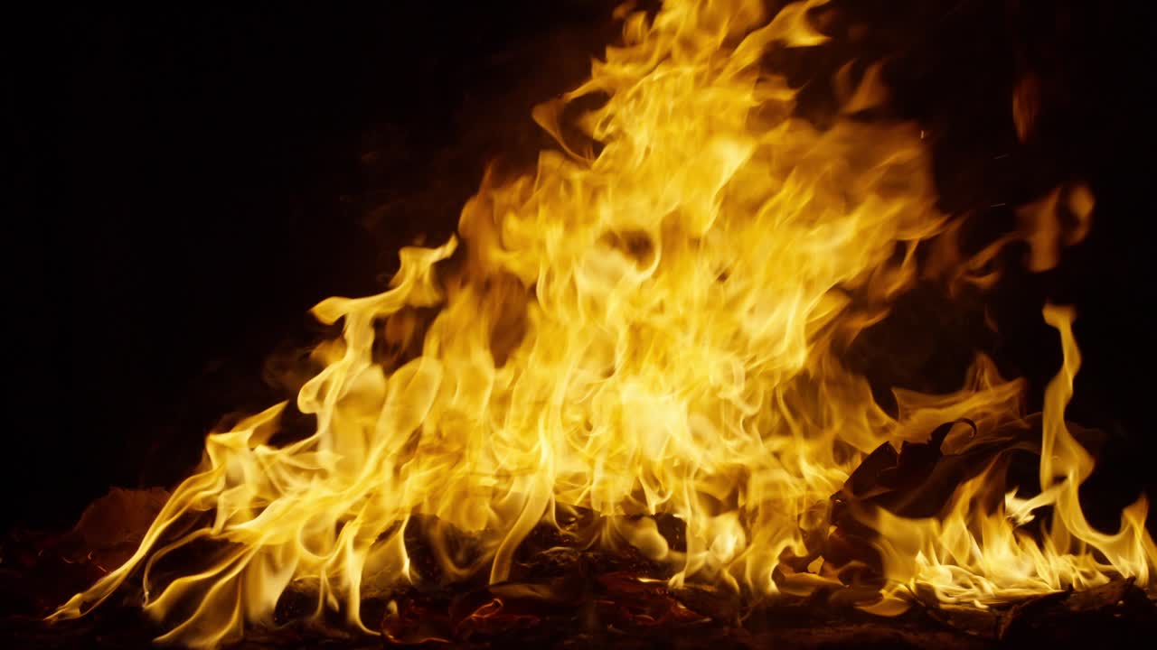 A bonfire burning and flickering at night in nature