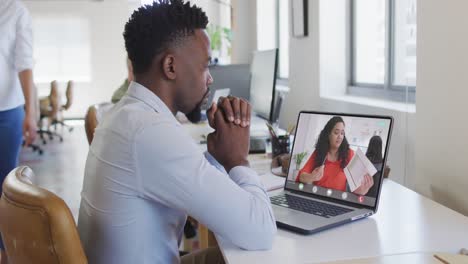 African-american-businessman-using-laptop-for-video-call-with-biracial-business-colleague