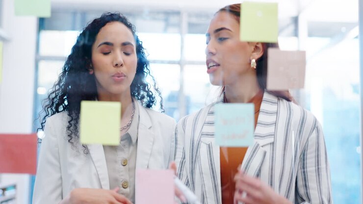 Donne d'affari, lavoro di squadra e soluzione su vetro