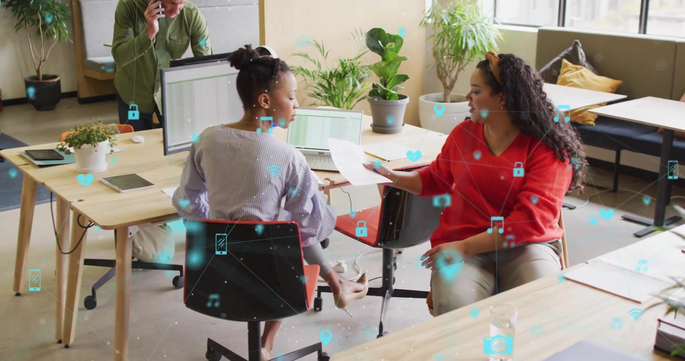 woman showing document to colleague in business meeting, causing swirling icons visualizing data