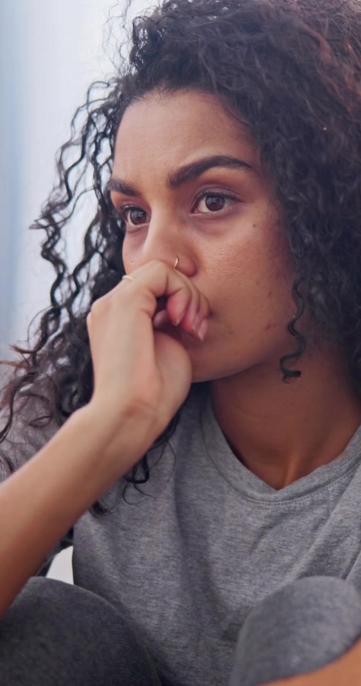 Pensive Young Woman Sitting and Thinking