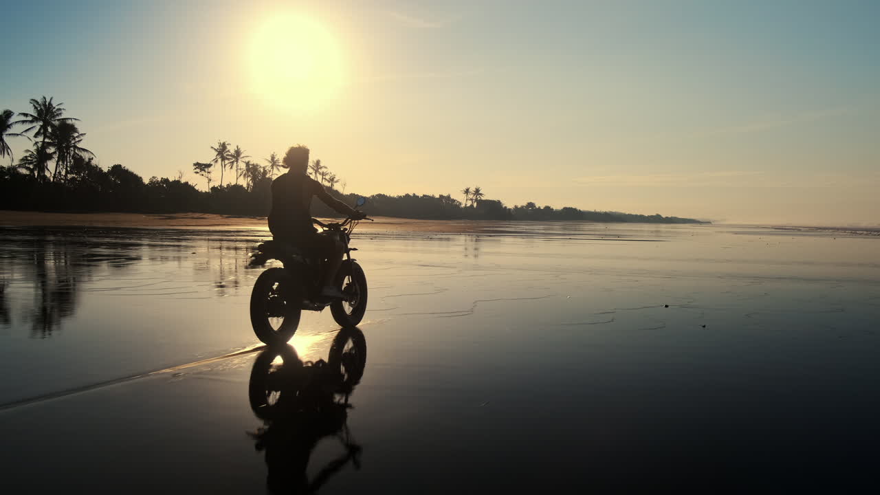 Man on Motorcycle at Sunrise Beach
