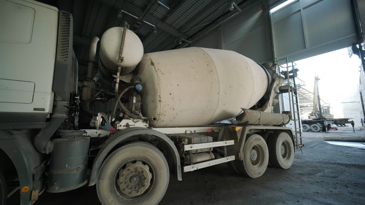 el mezclador de hormigón en la planta industrial. los constructores están construyendo una fábrica, un hangar.