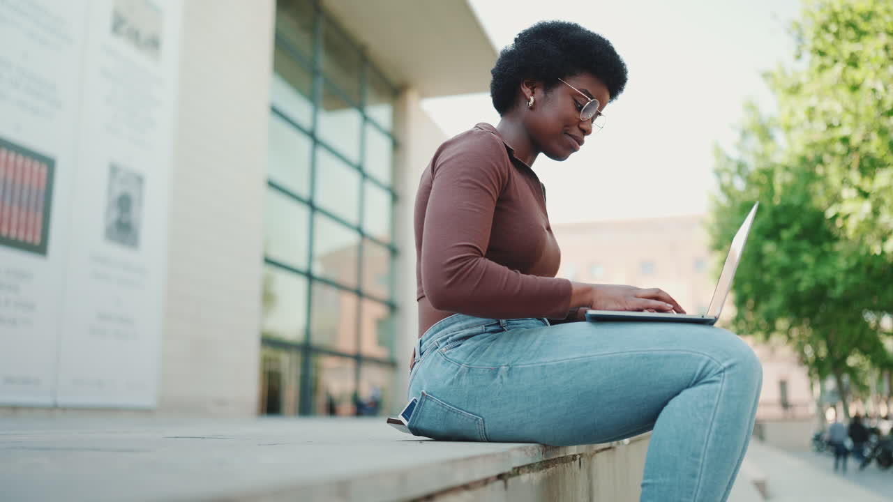Beautiful African student girl wearing casual studying outdoors