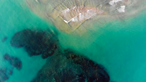 hermosa agua azul clara del mar que fluye sobre rocas y corales en las olas de la playa