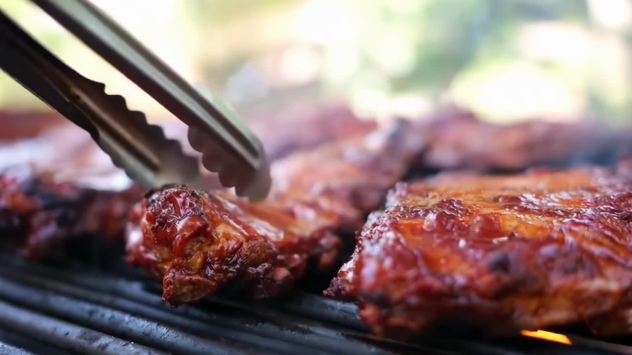 Close-up video of sizzling barbecue ribs on a grill, capturing juicy texture and smoky aroma