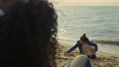 little child enjoying sea beach by parents. family chilling on holiday vacation.