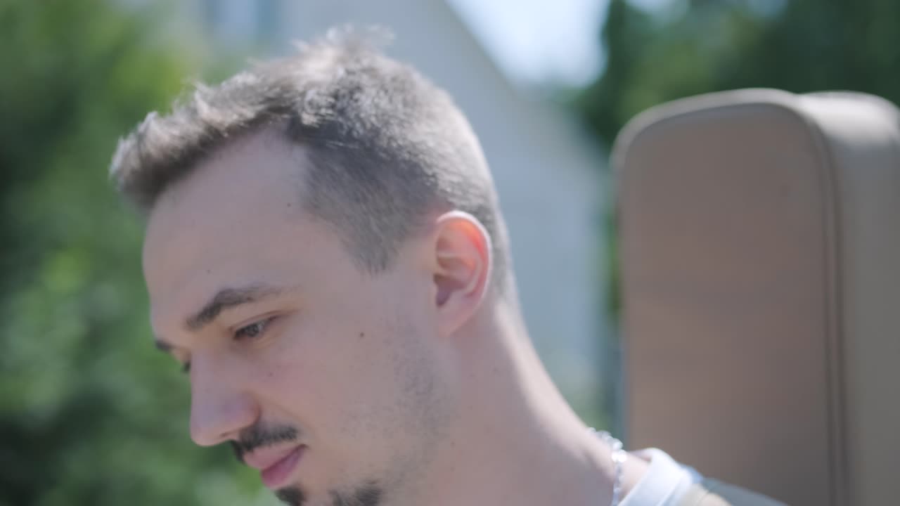 숲 근처의 거리에서 기타를 들고 는 젊은 남자