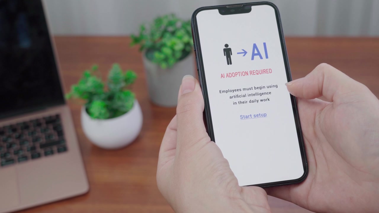 Person views an AI adoption required notification on a phone, prompting employees to begin using artificial intelligence at work.