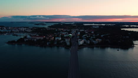 vista aérea sobre el puente lauttasaarensilta hacia lauttasaari, atardecer en helsinki, finlandia