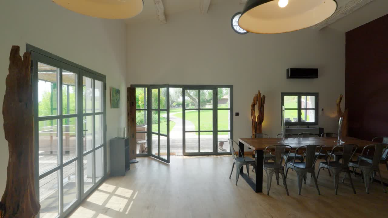 Lenta ripresa in allontanamento che rivela una sala da pranzo e cucina a pianta aperta in una villa