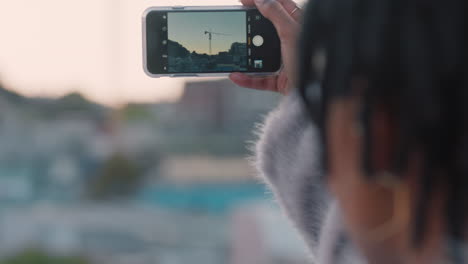 young african american woman taking photos of city using smartphone mobile camera enjoying sightseeing sharing vacation pictures on social media