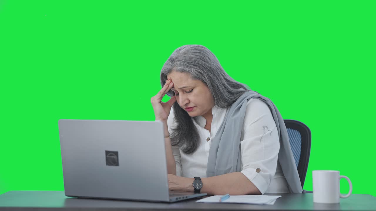 directora india senior tensa trabajando en la pantalla verde de la computadora portátil