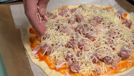 Hand-Mit-Selektivem-Fokus,-Die-Langsam-Käse-Auf-Hausgemachte-Pizza-Legt