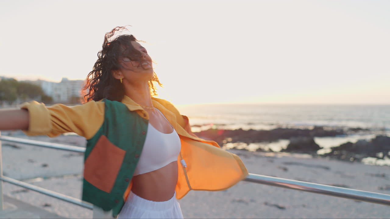 mujer feliz disfrutando de la puesta de sol en la playa