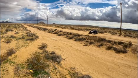 following an atv dune buggy on a trail in the mojave desert with an fpv drone