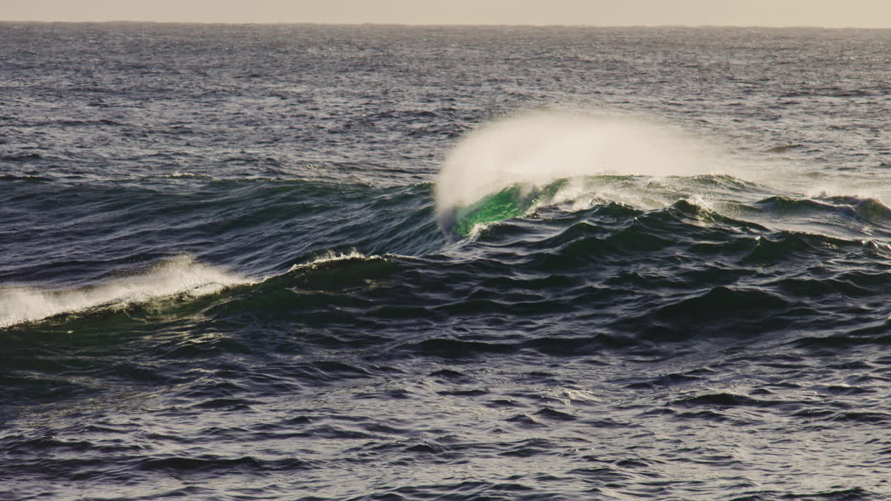 Calm ocean swell rolling toward shore in smooth rhythmic patterns under natural light, natural backdrop background of heavy shoulder
