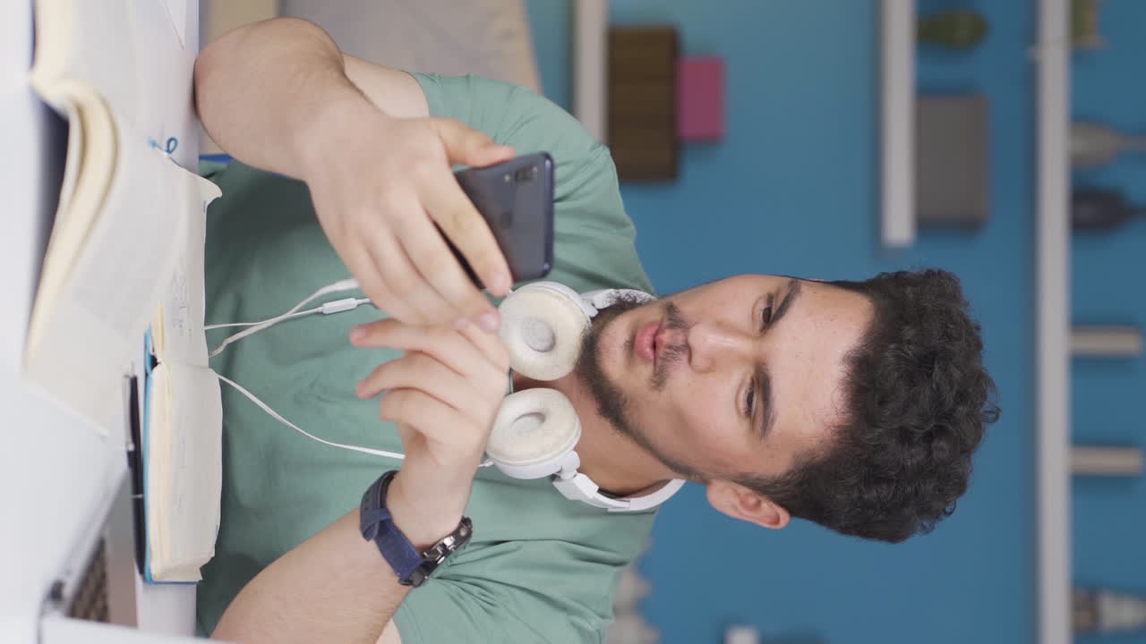 vídeo vertical de un estudiante masculino que le gusta la aplicación móvil.