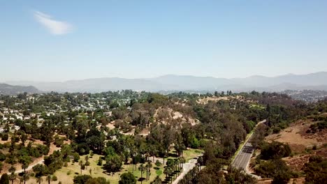 Road-downtown-Los-Angeles-with-Angeles-Nation-Forest-in-background-during-sunny-day-with-blue-sky