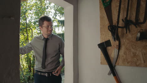 man looking outside of a shed door