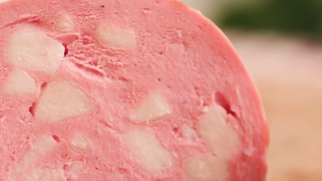 Ham italian mordatella, man Slices Of Traditional Italian antipasti mortadella sausage on a wooden cutting board, close up macro of chicken or turkey jamon, fat breakfast dish.