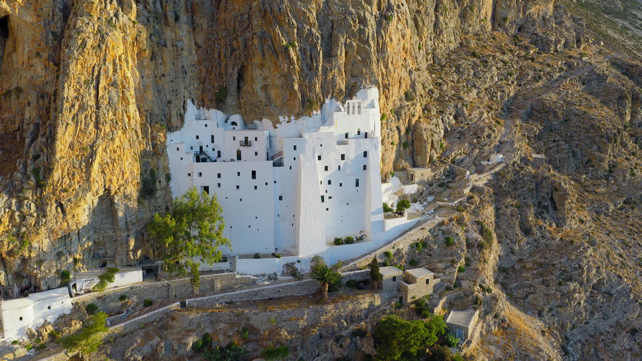 Holy Monastery of the Virgin Mary Chozoviotissa, The Panagia Hozoviotissa Monastery built on steep cliffside at sunrise, Amorgos Island, Revealing drone shot