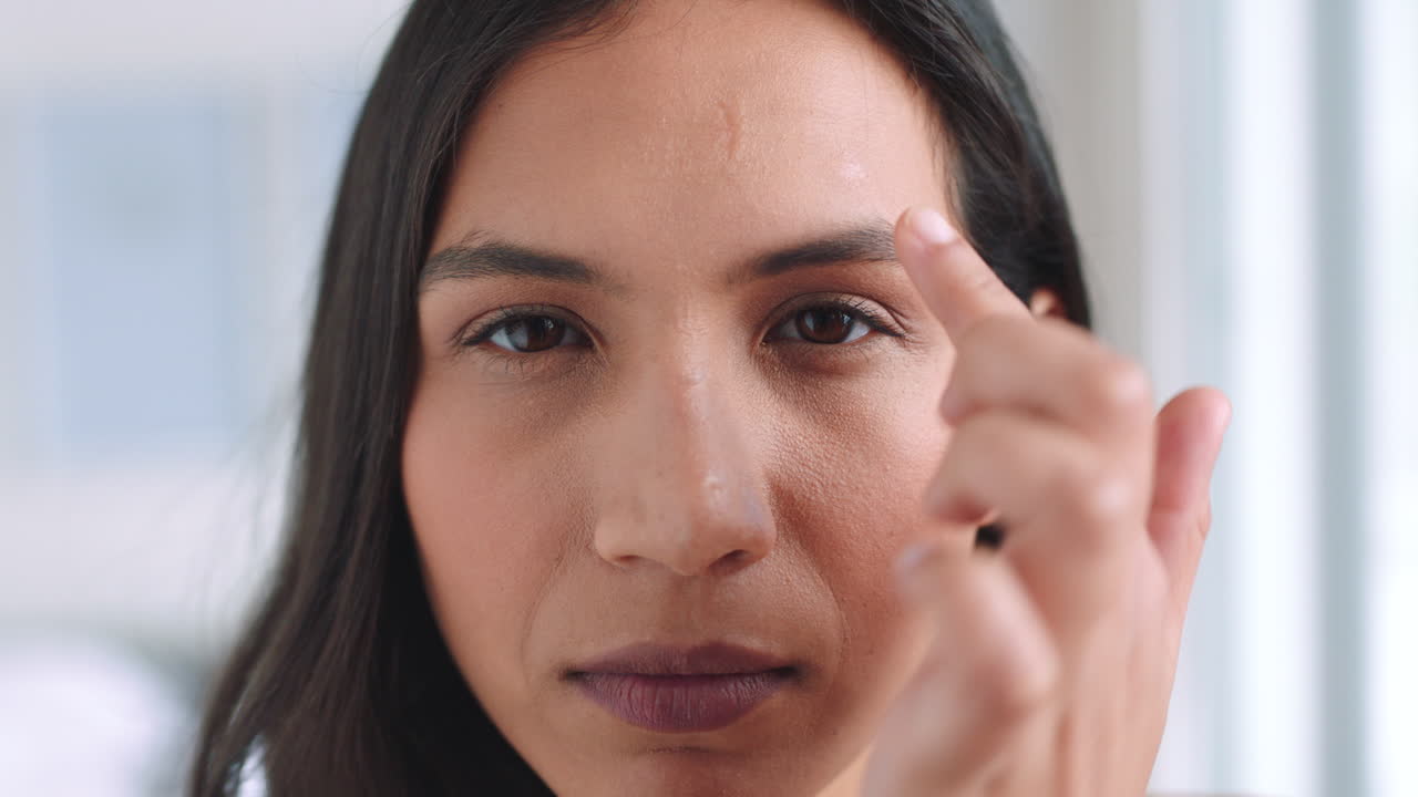 mujer comprobando su cara y cabello en un espejo