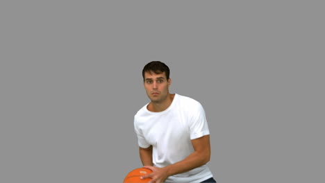 Un-Hombre-Guapo-Atrapando-Y-Lanzando-Una-Pelota-De-Baloncesto-En-Una-Pantalla-Gris.