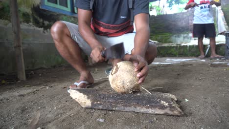 Man-Breaking-Edge-of-Coconut-with-Machete