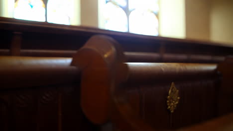 wooden church pew with stained glass window in background