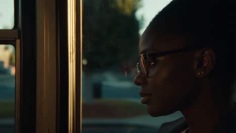 woman looking out window during golden hour