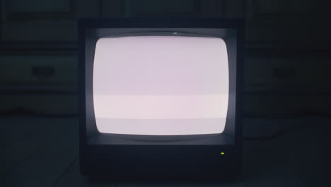 old television with static on a wooden floor